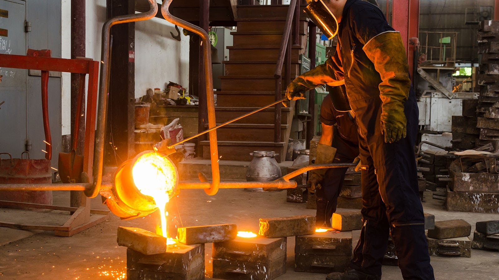 Metal casting process — molten metal being poured into a precision mold cavity for industrial component production